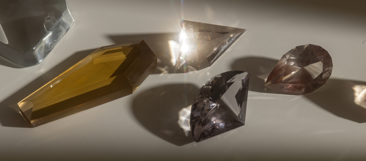 Collection of crystal or gemstone prisms on a reflective surface