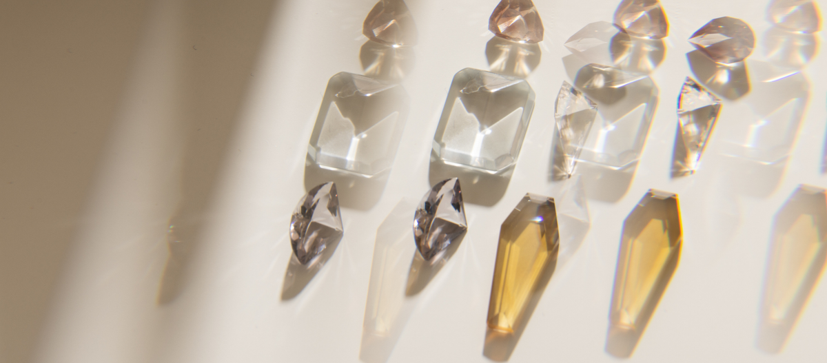 Crystal-like objects on a reflective surface with a light source creating shadows.
