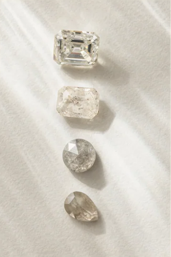Various clear and salt and pepper stones lined up vertically, all different cuts and sizes